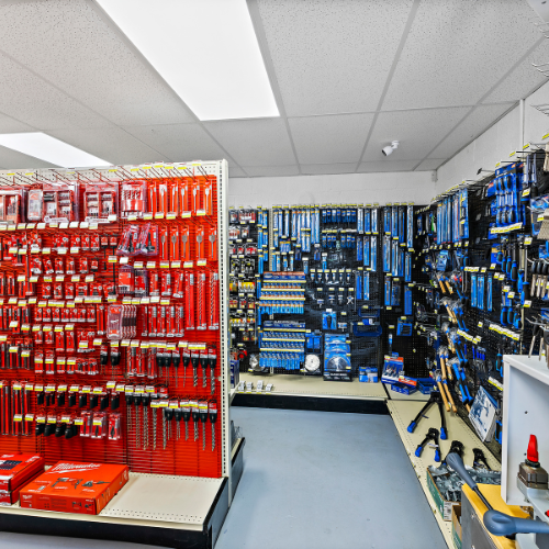 Milwaukee tools and accessories in the bright red packaging and the shelves are also red in this section, and Century Drill & Tool with royal blue packaging.