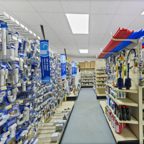 An aisle filled with plumbing supplies for sinks, faucets, toilets, showers, and baths, including pipes, plungers, drain cleaners, and more.