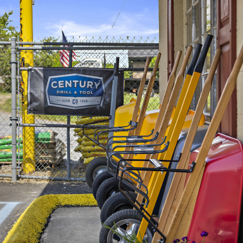 A Century Drill & Tool sign outside our store, with wheelbarrows in the forefront on the right side.